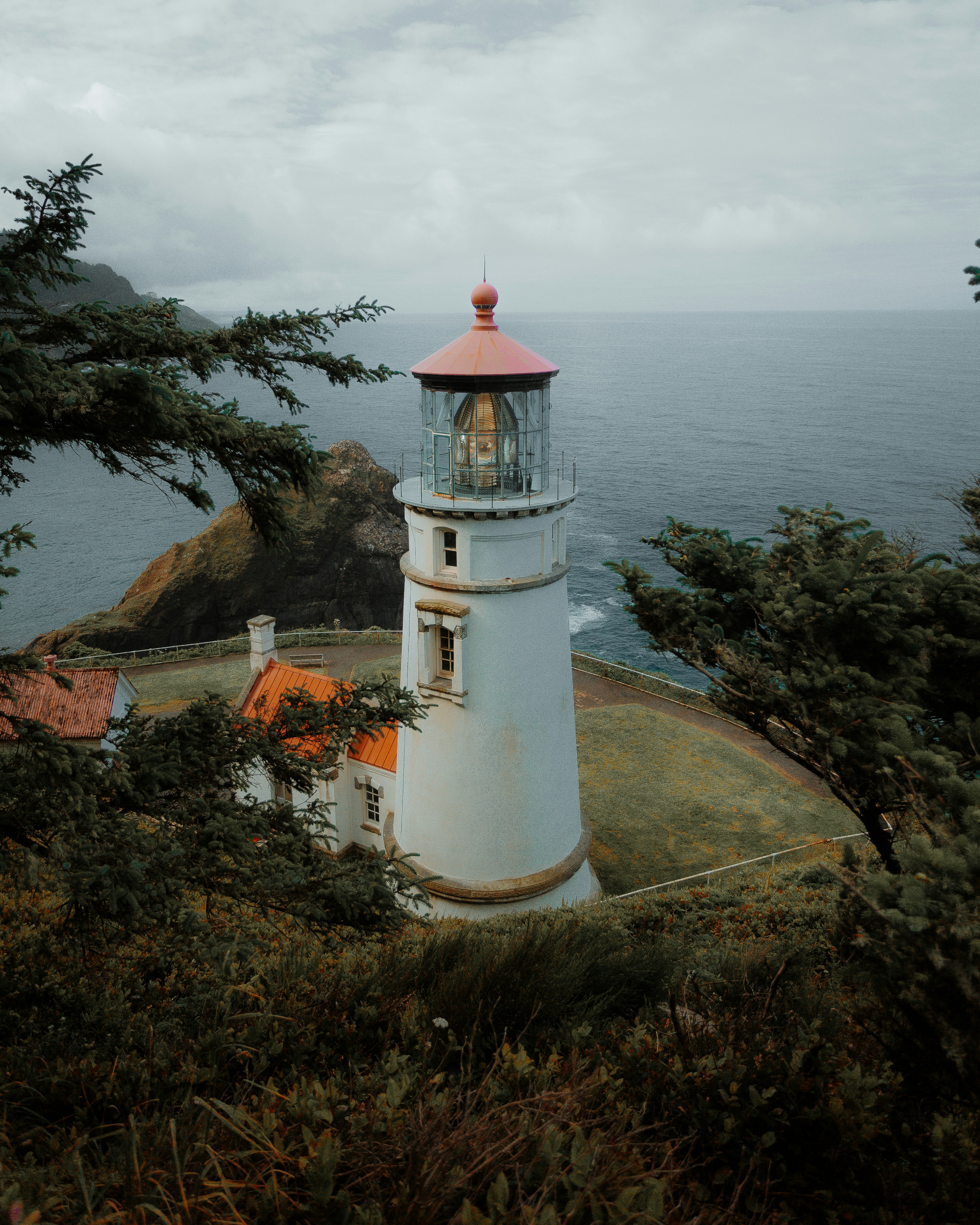 white and red lighthouse near body of water during daytime